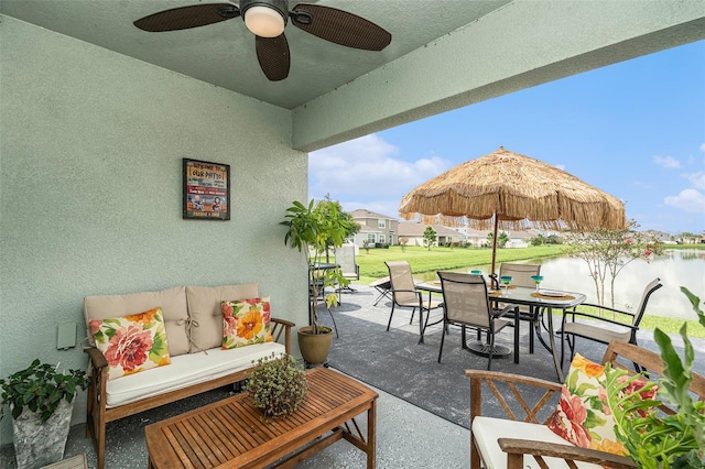 view of patio featuring a water view and ceiling fan