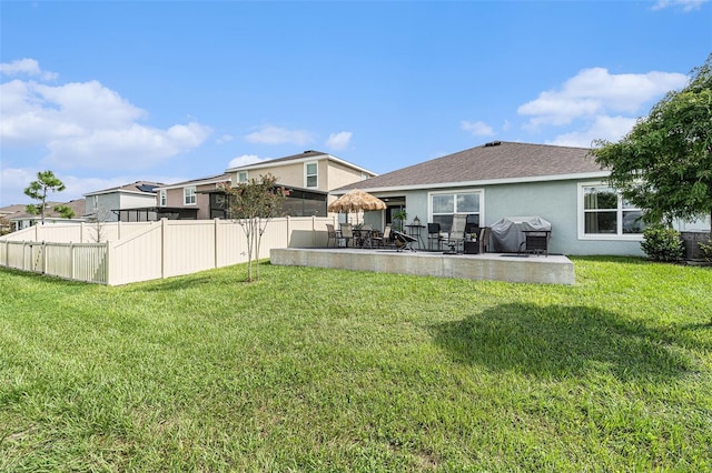 back of house with a lawn and a patio