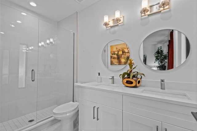 bathroom featuring vanity, toilet, and a shower with door