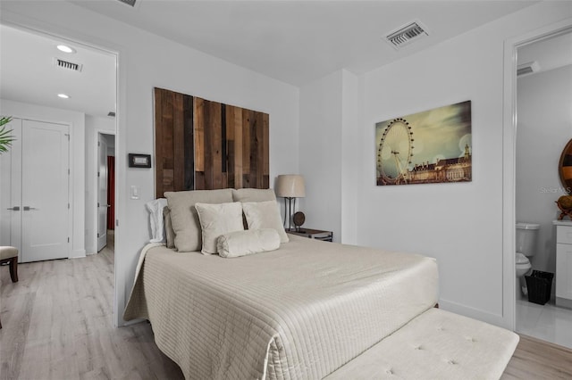 bedroom featuring light hardwood / wood-style flooring and ensuite bathroom