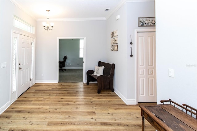 foyer featuring an inviting chandelier, light hardwood / wood-style flooring, and ornamental molding