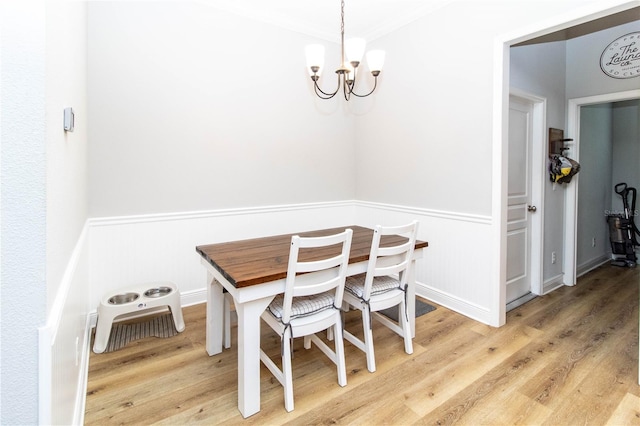 dining space featuring an inviting chandelier, hardwood / wood-style flooring, and ornamental molding