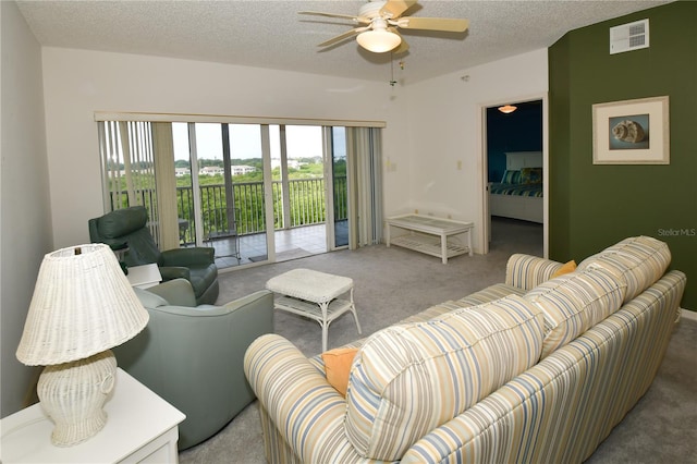 carpeted living room featuring a textured ceiling and ceiling fan