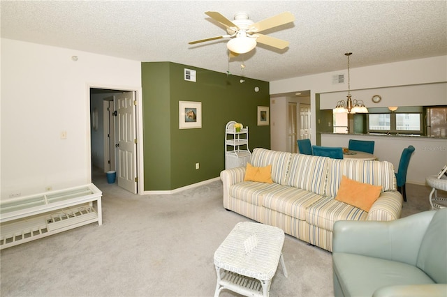 living room featuring a textured ceiling, ceiling fan with notable chandelier, and light carpet