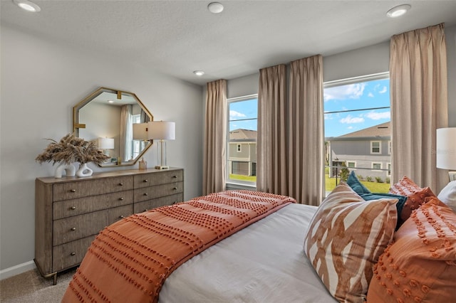 bedroom featuring light carpet and a textured ceiling