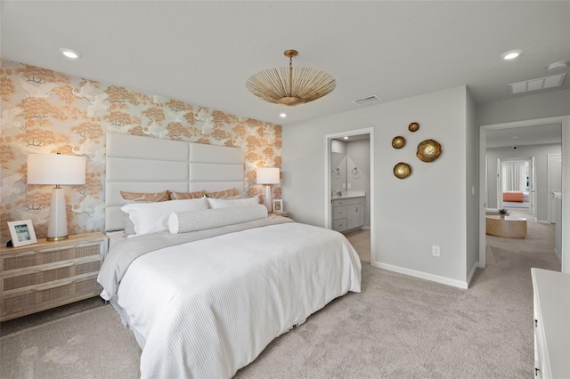 bedroom with light carpet and ensuite bath