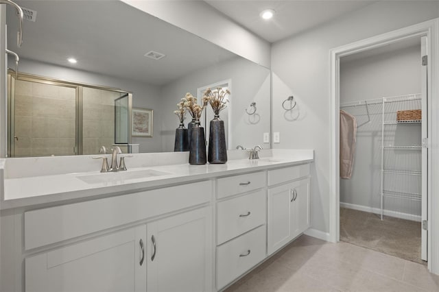 bathroom with tile patterned floors, vanity, and an enclosed shower