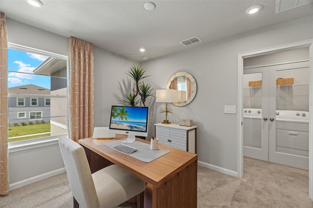 carpeted office space with a textured ceiling and a healthy amount of sunlight