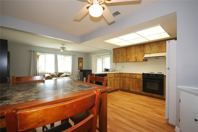 kitchen featuring decorative backsplash, light hardwood / wood-style floors, ceiling fan, and black appliances