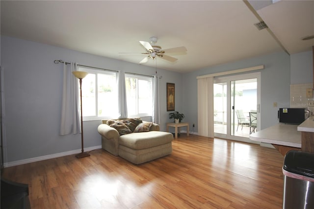 living room featuring ceiling fan and light hardwood / wood-style flooring