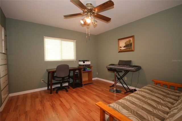 office with light wood-type flooring and ceiling fan