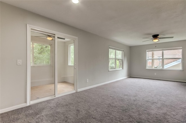 empty room with carpet, ceiling fan, plenty of natural light, and a textured ceiling