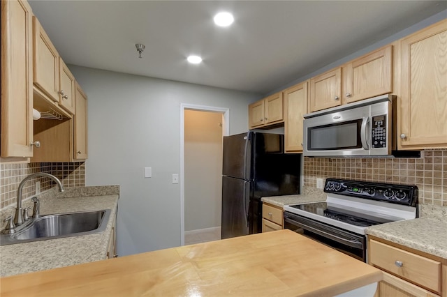 kitchen with electric range oven, light brown cabinets, and sink