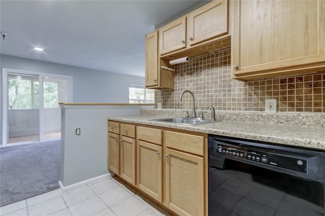 kitchen with light brown cabinetry, black dishwasher, plenty of natural light, and sink