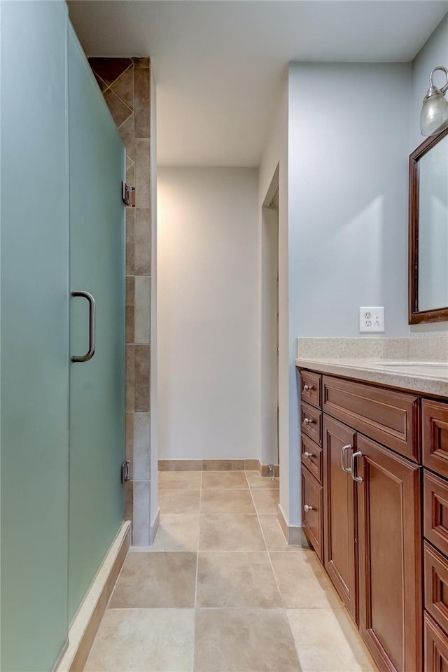 bathroom with tile patterned flooring, a shower with door, and vanity