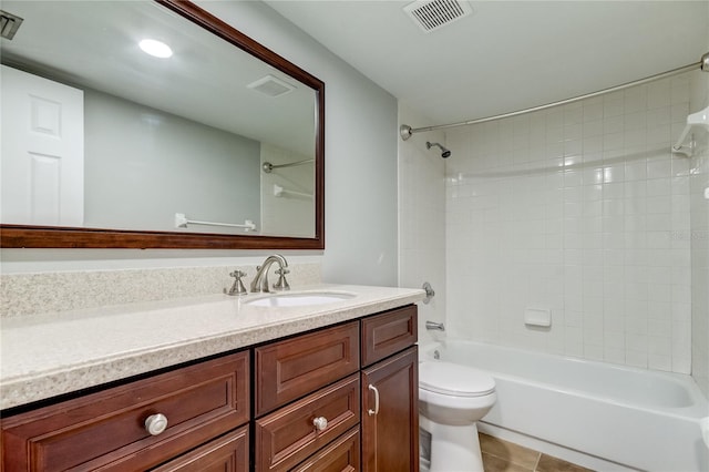 full bathroom featuring tiled shower / bath, vanity, toilet, and tile patterned floors