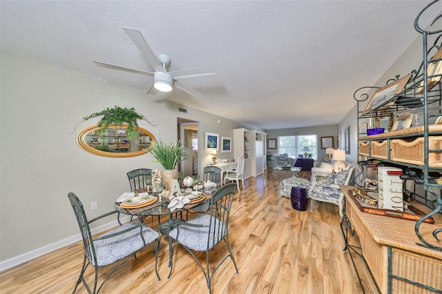 dining area with ceiling fan, a textured ceiling, and light hardwood / wood-style flooring