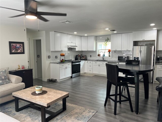 kitchen featuring dark wood-type flooring, sink, white cabinetry, stainless steel appliances, and ceiling fan