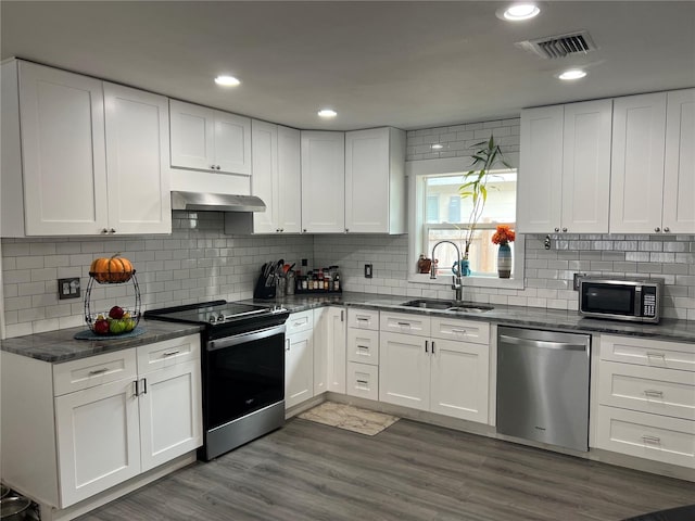 kitchen with sink, white cabinets, stainless steel appliances, exhaust hood, and dark hardwood / wood-style flooring