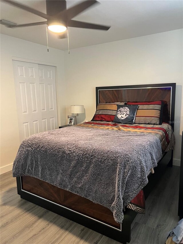 bedroom featuring a closet, hardwood / wood-style flooring, and ceiling fan