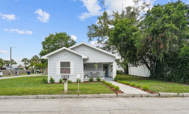 bungalow-style home with covered porch and a front lawn