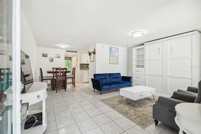 living room with a textured ceiling and light tile patterned floors