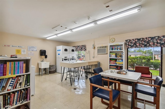 dining area featuring stacked washer and clothes dryer, an AC wall unit, and sink