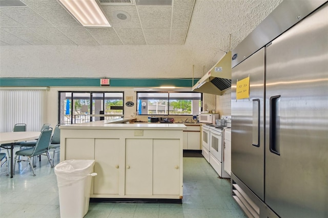 kitchen with white appliances, white cabinetry, and exhaust hood