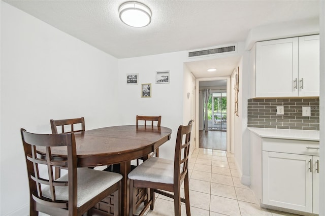 tiled dining space featuring a textured ceiling