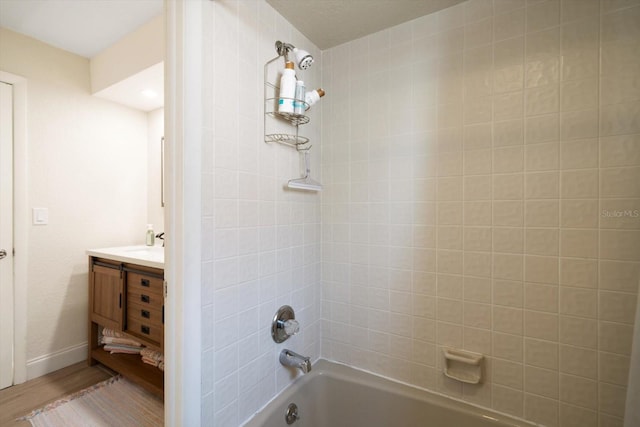 bathroom with vanity, tiled shower / bath, and hardwood / wood-style flooring