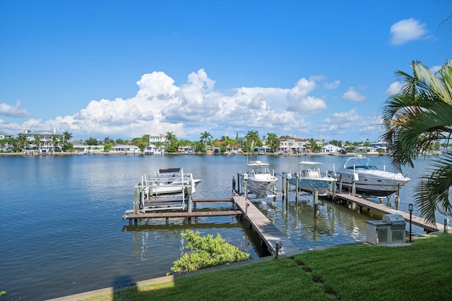 view of dock with a lawn and a water view