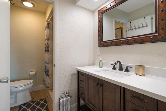 bathroom with walk in shower, vanity, toilet, and hardwood / wood-style flooring