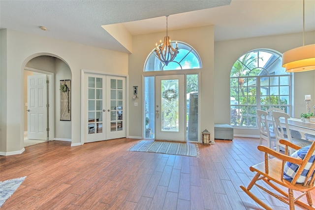 foyer featuring hardwood / wood-style floors, plenty of natural light, and french doors