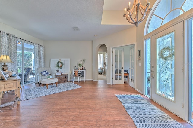 4923 Willow Ridge Ter, Valrico, FL 33596 - foyer with a textured ceiling, visible vents, arched walkways, a chandelier, and light wood-style flooring