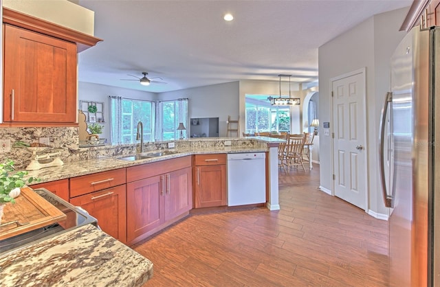 kitchen with light hardwood / wood-style floors, sink, ceiling fan with notable chandelier, white dishwasher, and stainless steel fridge