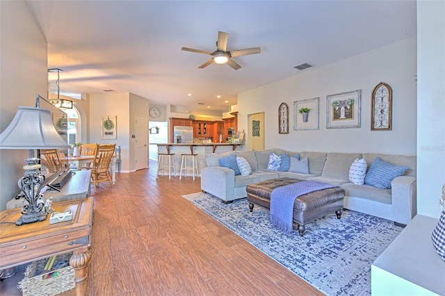 living room featuring wood-type flooring and ceiling fan