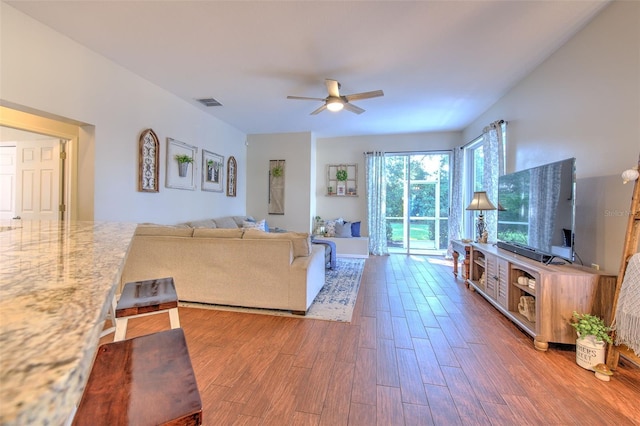 living room featuring ceiling fan and hardwood / wood-style flooring