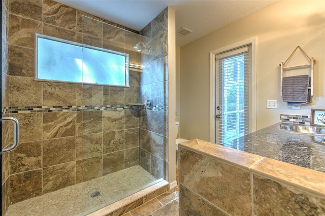 bathroom with sink, an enclosed shower, and toilet