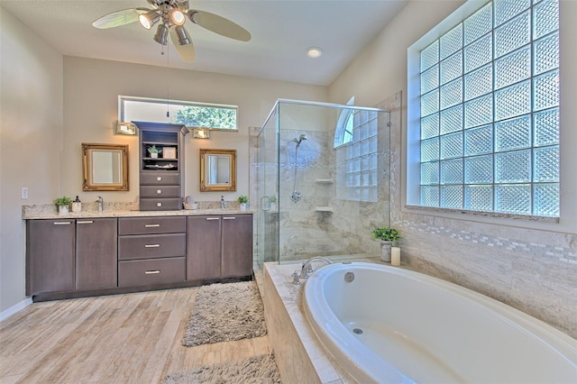 bathroom with vanity, ceiling fan, plus walk in shower, and hardwood / wood-style flooring