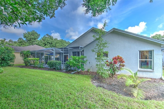 view of side of home featuring glass enclosure and a yard