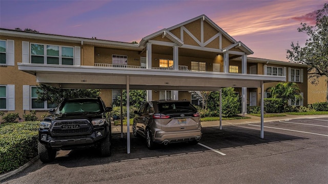 view of front facade featuring a balcony and a carport