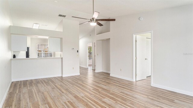 unfurnished living room with light wood-type flooring, ceiling fan, and high vaulted ceiling