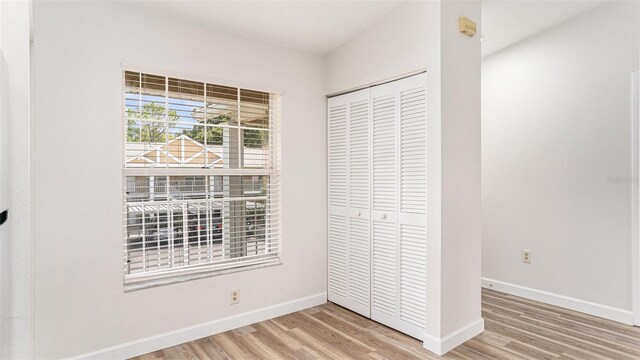 unfurnished bedroom with a closet and hardwood / wood-style floors