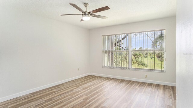 spare room with ceiling fan, a textured ceiling, and light hardwood / wood-style floors