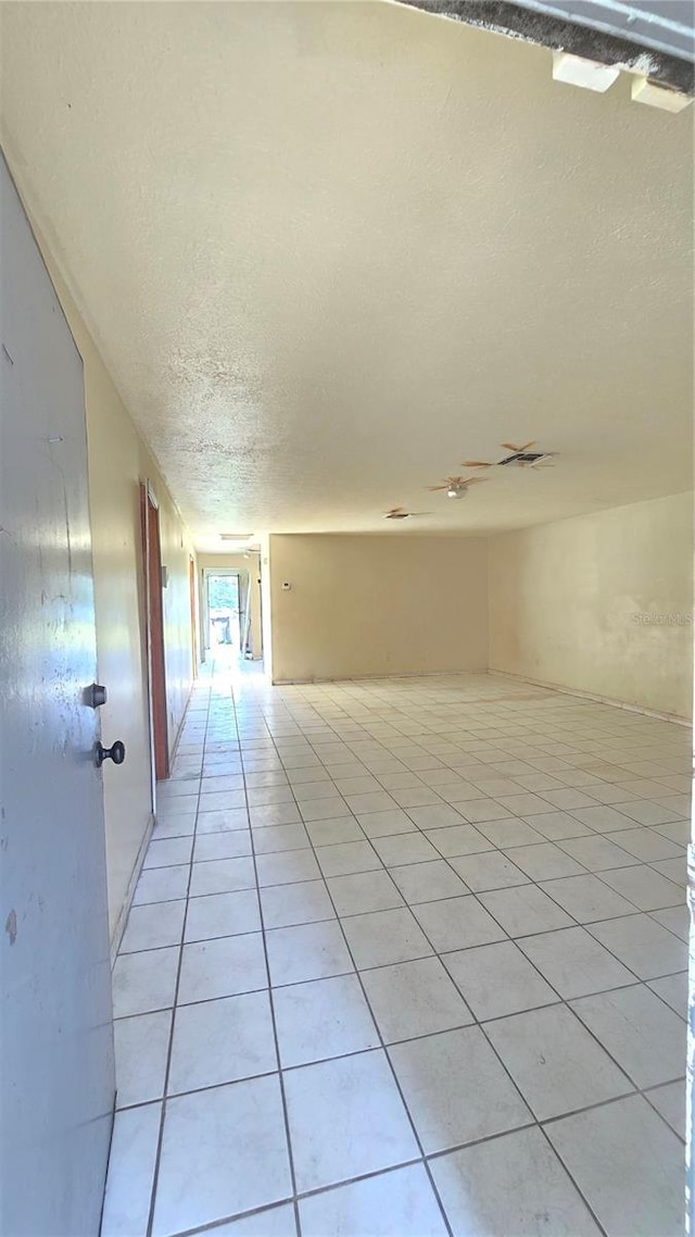 interior space with a textured ceiling and light tile patterned floors