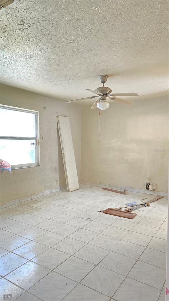 unfurnished room featuring ceiling fan and a textured ceiling