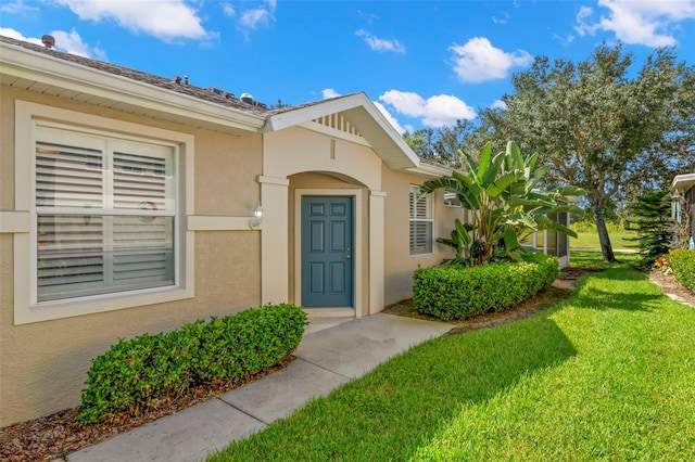 entrance to property with a lawn