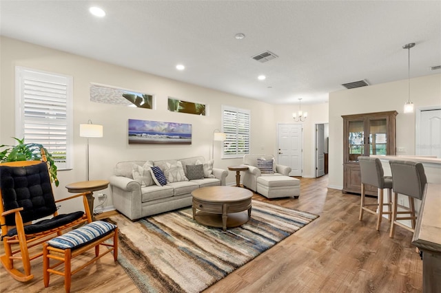 living room featuring a notable chandelier, hardwood / wood-style floors, and plenty of natural light