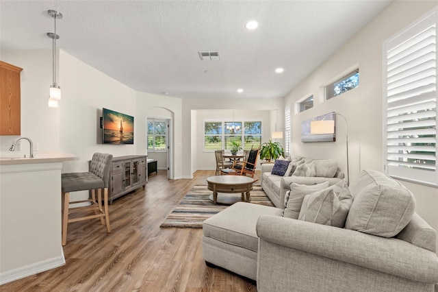 living room featuring a textured ceiling and light hardwood / wood-style flooring