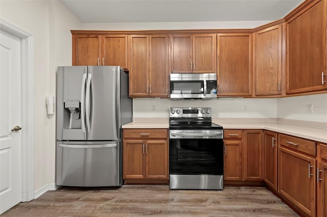 kitchen featuring light wood-type flooring and appliances with stainless steel finishes